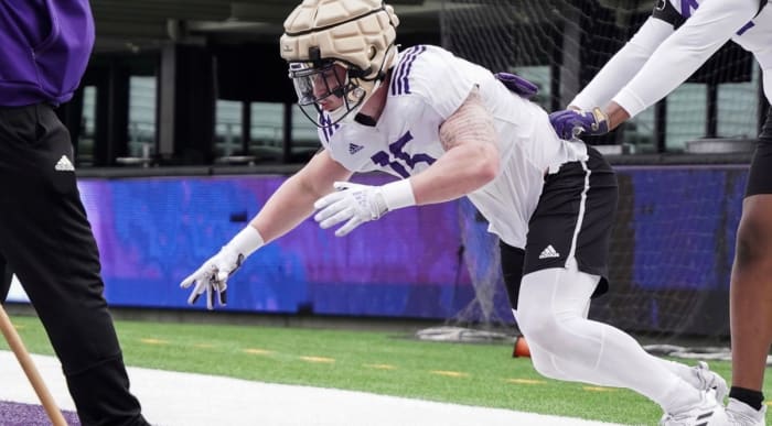 Zach Durfee runs through spring drill with resistance from a teammate.